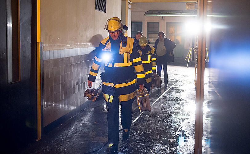 Einsatzkräfte verlassen das Brandhaus.