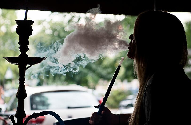 Eine junge Frau raucht in einer Shisha-Bar in Berlin eine Wasserpfeife: Der Absatz von Shisha-Tabak legte im zweiten Quartal 2016 im Vergleich zum Vorjahreszeitraum um mehr als 50 Prozent auf mehr als 630 Tonnen zu. Foto: Soeren Stache