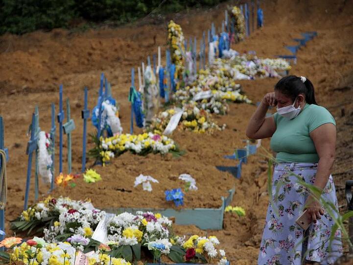 Eine Frau trauert an einem Grab auf einem Friedhof in Manaus.