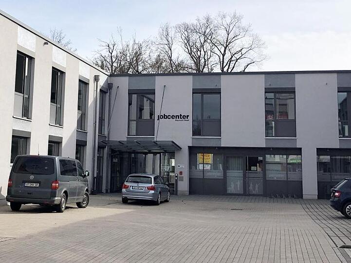 Zwei Zivilfahrzeuge der Polizei (l) stehen vor dem Jobcenter in Bayreuth. Foto: Ferdinand Merzbach/dpa/Archivbild