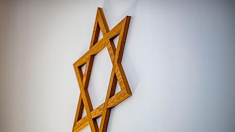 Ein Davidstern hängt an einer Wand im Gebetsraum einer Synagoge.