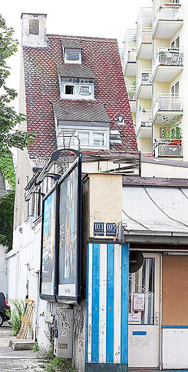 Gut angestrichen: weiß-blaue Streifen an einem schmalen Haus.