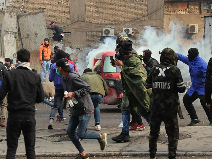 Rauch und Tränengas steigen bei Zusammenstößen zwischen Demonstranten und Sicherheitskräften in Bagdad auf.