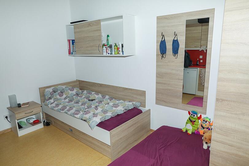 Ein Bett, ein paar Kinderbücher im Regal, zwei aufeinander gestapelte Matratzen für die zwei kleinen Töchter. So sieht Hanna A.s Zimmer aus.
