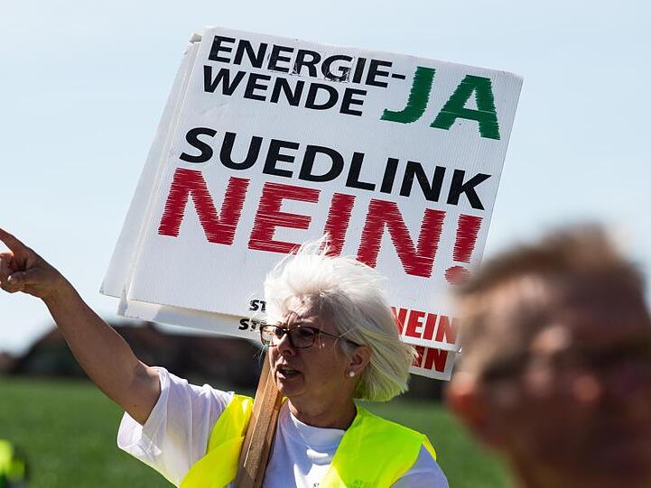 Ein Demonstrant hält ein Schild mit der Aufschrift "Südlink Nein". Foto: Swen Pförtner/dpa/Archivbild