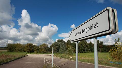 Ein Schild mit der Aufschrift "Gewerbegebiet" steht vor einer unbebauten Sackgasse.