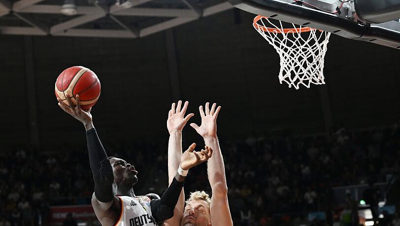 Deutschlands Dennis Schröder (l) spielt gegen Sloweniens Jaka Balzac den Ball.