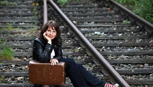 Jana Buchholz mit einem Koffer auf den Gleisen. Jana Buchholz mit einem Koffer auf den Gleisen.