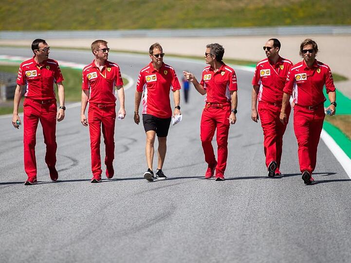 Sebastian Vettel (M) geht mit seinem Team die Rennstrecke in Spielberg ab.