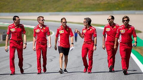 Sebastian Vettel (M) geht mit seinem Team die Rennstrecke in Spielberg ab.