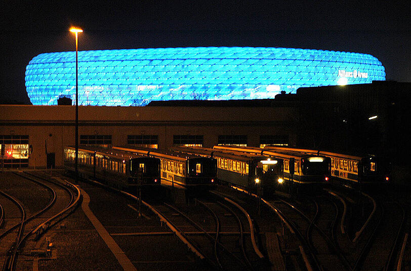 Das Depot der Münchner U-Bahn. Im Hintergrund ist die Allianz Arena zu sehen. Bei Heimspielen der Löwen ist das Stadion blau erleuchtet.