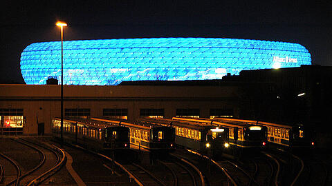 Das Depot der Münchner U-Bahn. Im Hintergrund ist die Allianz Arena zu sehen. Bei Heimspielen der Löwen ist das Stadion blau erleuchtet.