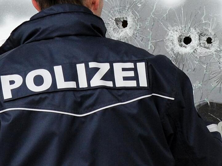 Ein Polizist markiert nach dem Amoklauf Einschusslöcher in einer Scheibe. (Archivbild)
