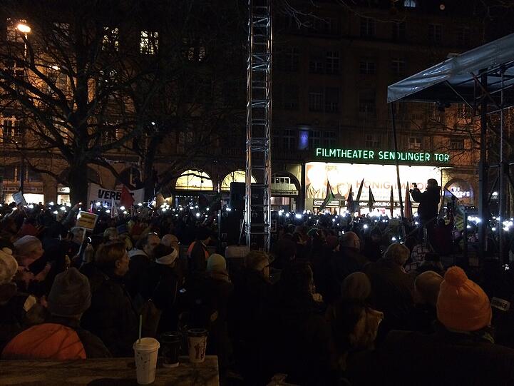 Die Gegendemonstranten machen ihre Handy-Lichter an.