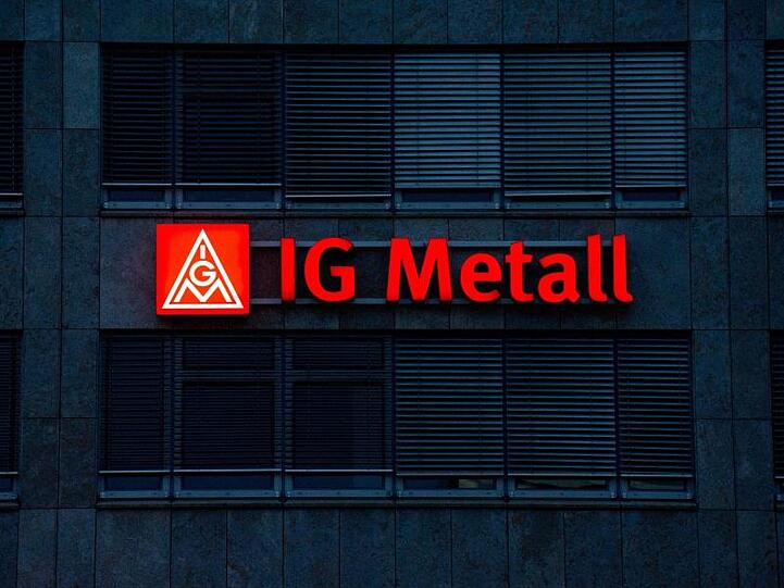 Das beleuchtete IG Metall-Logo auf einer Fassade. Foto: Marijan Murat/Archiv