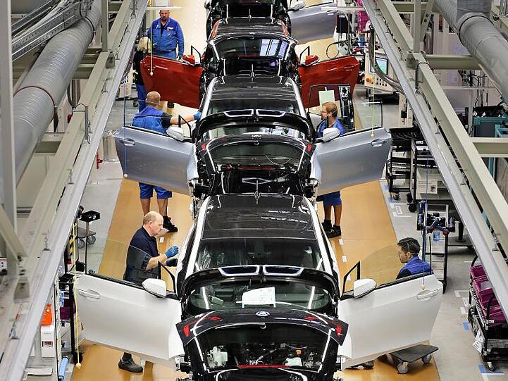 BMW-Mitarbeiter arbeiten in der Produktion. Foto: Jan Woitas/dpa-Zentralbild/dpa