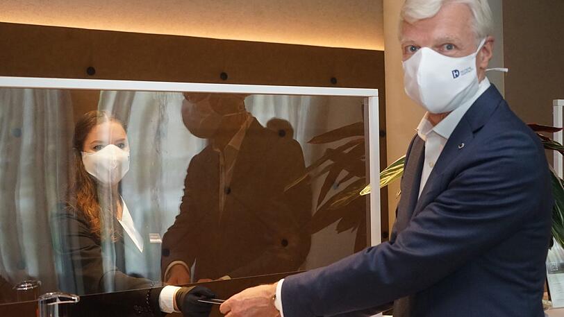 Die Rezeptionisten stehen jetzt hinter Plexiglasscheiben und arbeiten in Maske und Handschuhen.