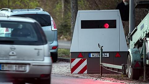 Ein Auto fährt an einem mobilen Blitzwagen, einem Geschwindigkeitsmessanhänger der Marke Votronic, vorbei.