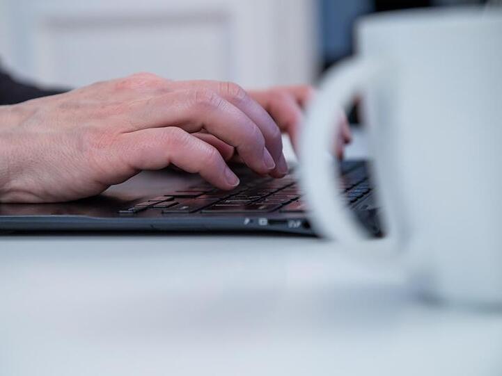 Der Kaffeebecher neben der Tastatur statt auf dem Tisch des Cafés "nebenan" - viele Beschäftigt arbeiten ohne Pause.