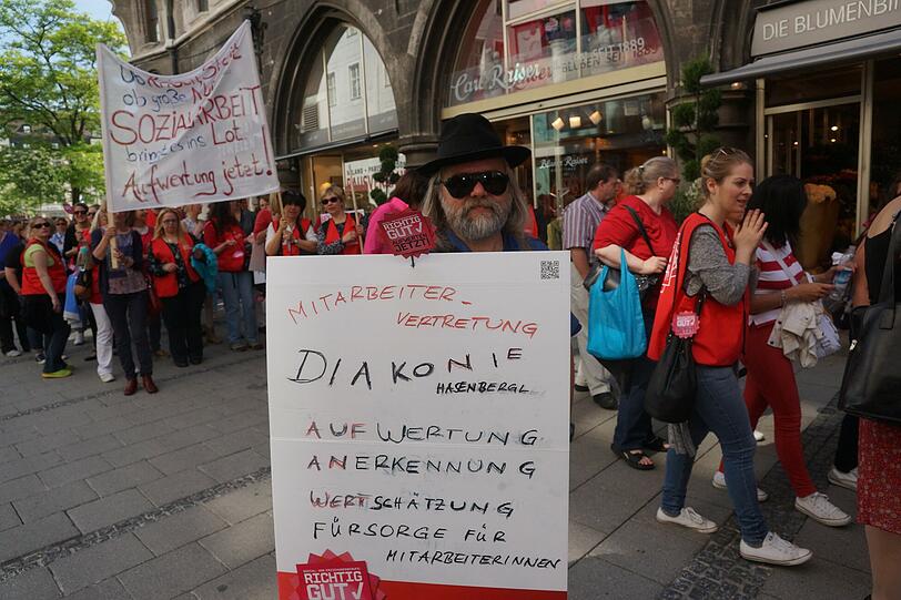 Erzieherinnen, Mütter und Sozialarbeiterinnen und Unterstützer bei Menschenkette am Marienplatz in München.