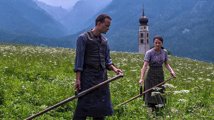 August Diehl und Valerie Pachner als das Bauernpaar Jägerstätter hier vor der Kirche St. Konstantin in Völs am Schlern.