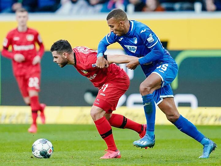 Hoffenheims Kevin Akpoguma (r) hält Leverkusens Kevin Volland (l) im Zweikampf fest.
