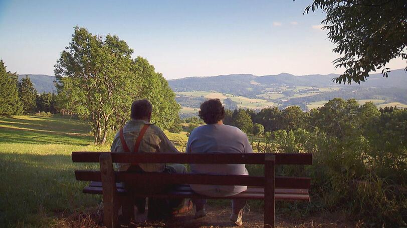Der herzliche Hesse Albert (52) und Sabine (47) aus Bayern genießen die Aussicht bei einem Picknick im Wald.