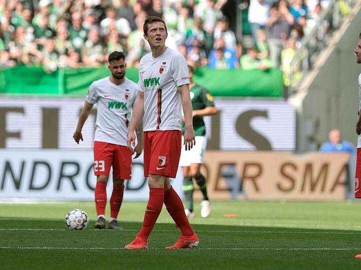 Augsburgs Marco Richter (l-r), Michael Gregoritsch und Daniel Baier stehen nach dem 6:0 für den VfL Wolfsburg auf dem Rasen. Foto: Peter Steffen