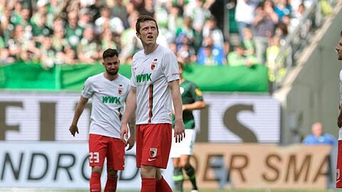 Augsburgs Marco Richter (l-r), Michael Gregoritsch und Daniel Baier stehen nach dem 6:0 für den VfL Wolfsburg auf dem Rasen. Foto: Peter Steffen