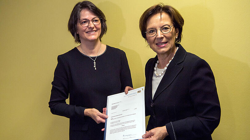 Bayerns Familienministerin Emilia Müller (rechts, CSU) übergibt der Leiterin der Kinderschutzambulanz, Elisabeth Mützel, einen Förderbescheid über 1,7 Millionen Euro an das Institut für Rechtsmedizin in München.