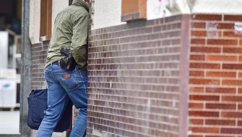 Ein Polizeibeamter betritt ein Haus in Bonn. Laut Staatsanwaltschaft konnten die Beamten mutmaßliche Beweismittel sicherstellen.