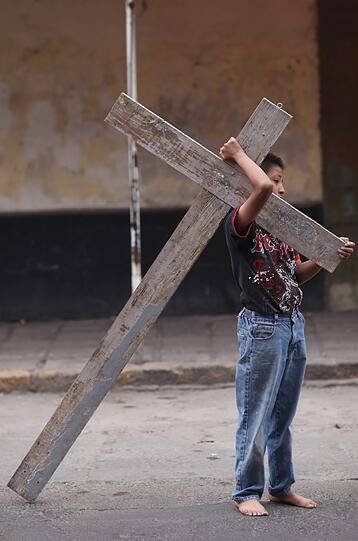 Ein Junge trägt ein Kreuz während der Osterprozession in Mexiko Stadt, Mexiko.