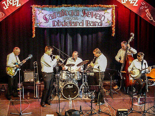 In folgender Besetzung sind die Saratoga Seven beim Truderinger Jazzfrühschoppen zu hören: Gerald Kresse (Trompete), Simon Hammerschmid (Alt-Sax, Klarinette), Trevor Courtney (Banjo, Bluesharp, Gitarre, Gesang, Posaune), Ulrich Walcher (Alt-Sax, Bariton-Sax, Gesang, Banjo), René Filous (Kontrabass) und Werner Krötz (Gesang, Schlagzeug).