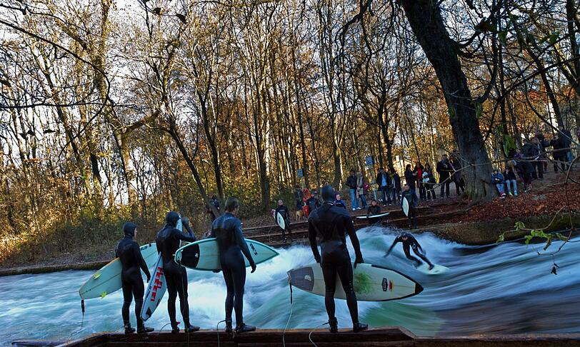 Surfen am Eisbach statt Snowboarden in den Bergen: Diese Surfer nutzen die frühlingshaften Temperaturen am 1. Adventswochenende.