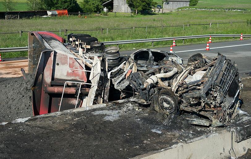 Rettungskräfte auf der Autobahn A8 bei Sulzemoos (Oberbayern) an einem ausgebrannten Lastwagen. Zwei weitere Autos sind in den Auflieger des Lastwagens gefahren. Bei dem Unfall kam mindestens eine Person ums Leben.
