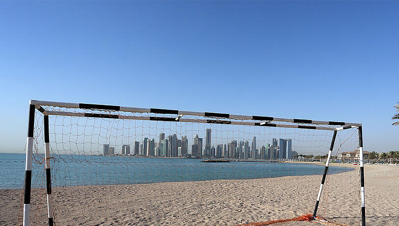 Ein Fußballtor steht vor der Skyline von Doha (Katar) (Symbolbild). Ein Fußballtor steht vor der Skyline von Doha (Katar) (Symbolbild).