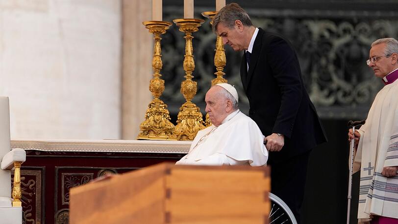 Papst Franziskus wird im Rollstuhl an dem Sarg des verstorbenen emeritierten Papstes Benedikt XVI. während öffentlichen Trauermesse für den emeritierten Papst Benedikt XVI. auf dem Petersplatz gefahren. (Archivbild)