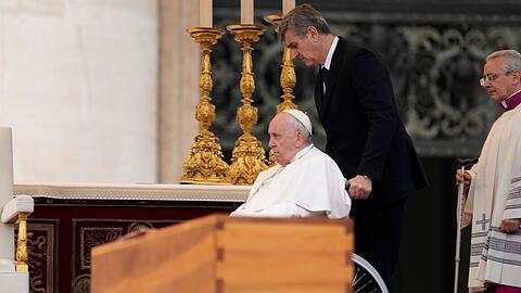 Papst Franziskus wird im Rollstuhl an dem Sarg des verstorbenen emeritierten Papstes Benedikt XVI. während öffentlichen Trauermesse für den emeritierten Papst Benedikt XVI. auf dem Petersplatz gefahren. (Archivbild)