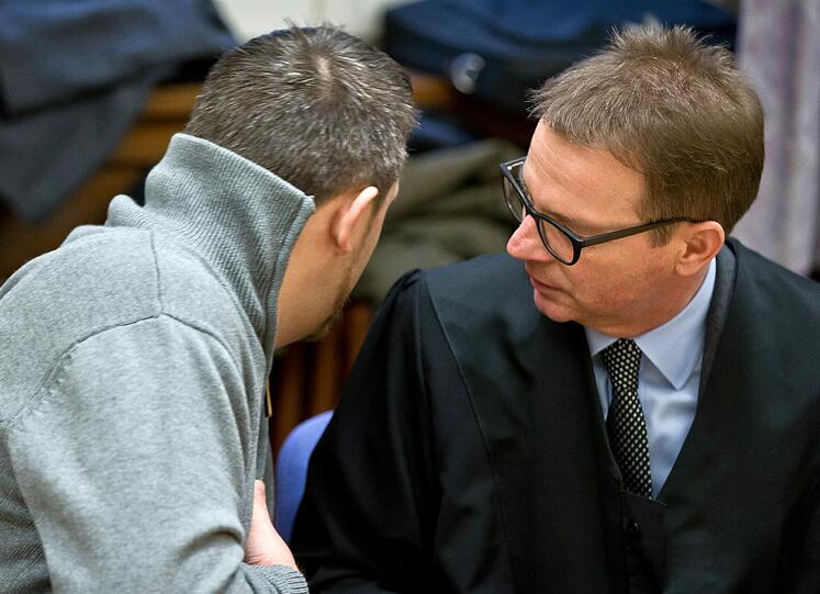 Stefan S. (l), Komplize des Bordellbetreibers, unterhält sich am 12.12.2013 im Sitzungssaal im Landgericht in Schweinfurt zu Verhandlungsbeginn mit seinem Anwalt Ulrich Spieß (Archivbild).