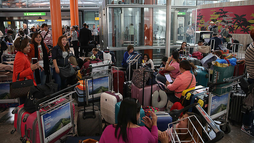 Gestrandete Passagiere stehen mit ihrem Gepäck im Terminal 5 des Flughafen Heathrow, nachdem es durch einen Ausfall des IT-Systems der Fluggesellschaft British Airways zu zahlreichen Flugausfällen und Verspätungen kam.