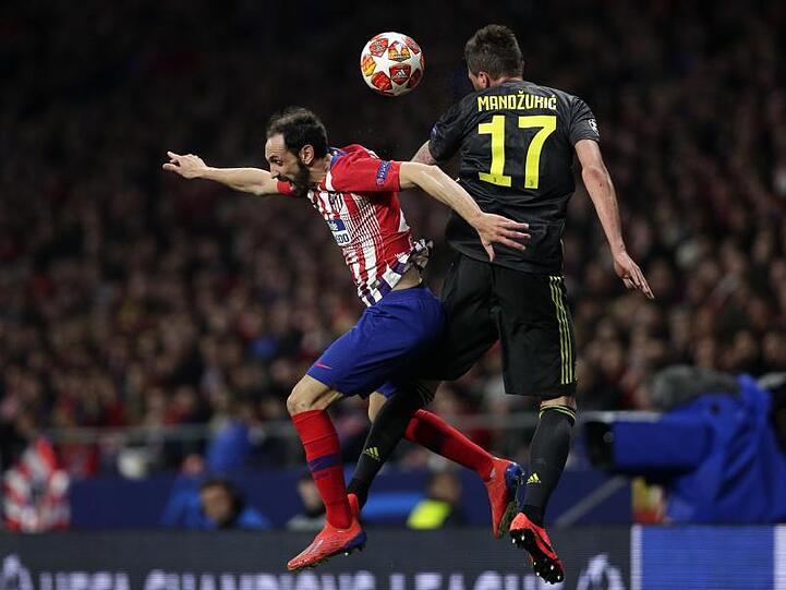 Atleticos Juanfran Torres (l) und Juve-Stürmer Mario Mandzukic kämpfen um den Ball.