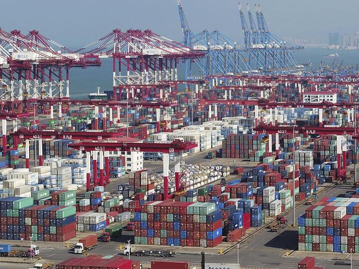 Im Hafen von Qingdao stehen Container und Containerbrücken.
