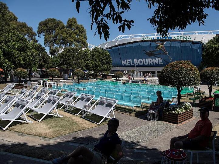 Zuschauer sitzen im Schatten von Bäumen während der Australian Open in Melbourne.