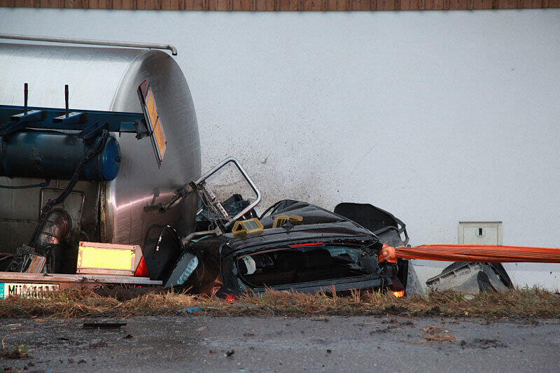Ein mit 25 Tonnen Rahm beladener Lkw stößt am Sonntagmorgen mit einem BMW zusammen, stürzt in einen Graben und begräbt das Auto halb unter sich.