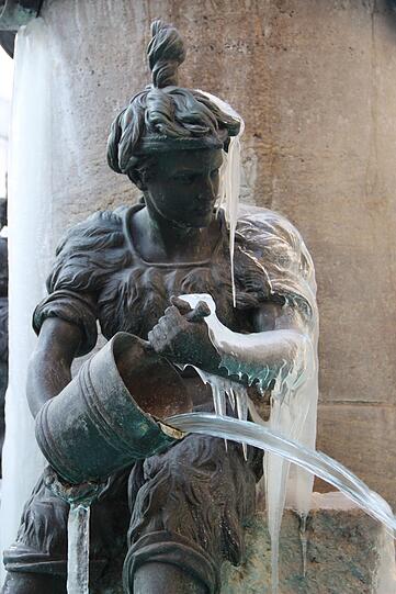 Das Wasser am Fischbrunnen fließt &ndash; und der bronzene Metzgersbursche hat einen eisigen Umhang.