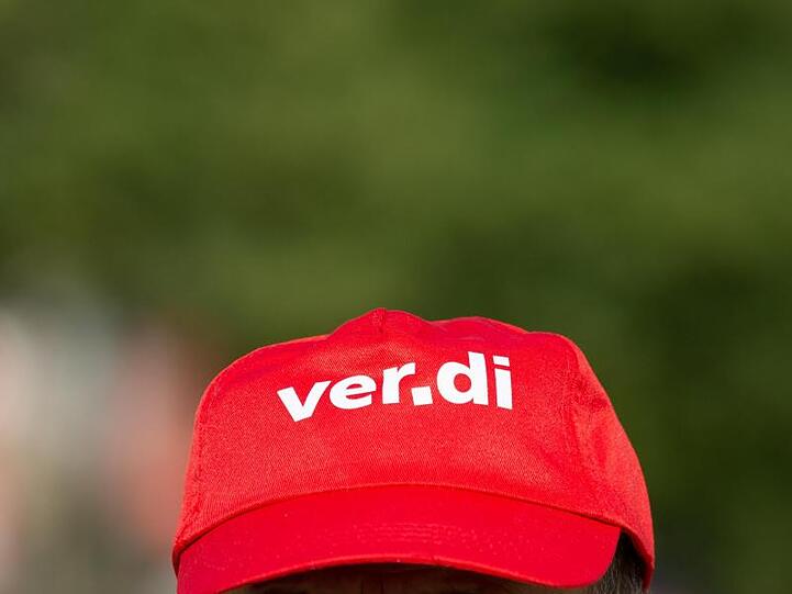 Ein Angestellter trägt beim Warnstreik eine Mütze mit dem Verdi Logo. Foto: Christophe Gateau/Archivbild