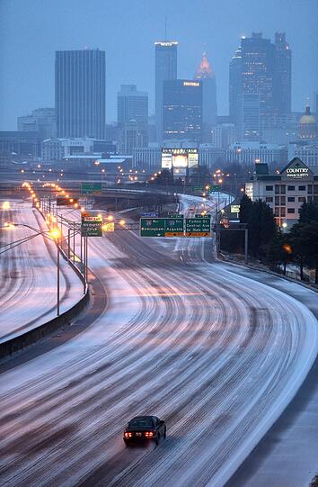 Ein einsames Auto auf einem verschneiten Highway südlich von Atlanta-Downtown.