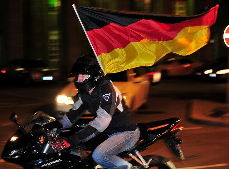 Autokorso neu interpretiert: Hier fährt ein glücklicher Deutschland-Fan auf dem Bike durch die Nacht.