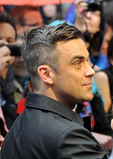 Weltstar im Fan-Gewusel: Robbie Williams verteilte Autogramme vor dem Mathäser-Kino.