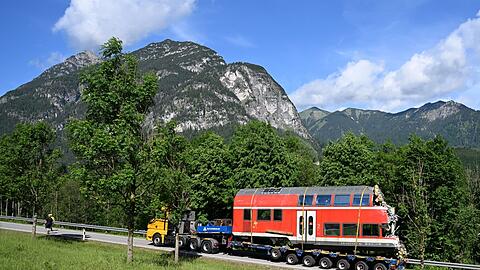 Ein Sattelschlepper transpotiert einen Teil des auseinandergeschnittenen Waggons ab.